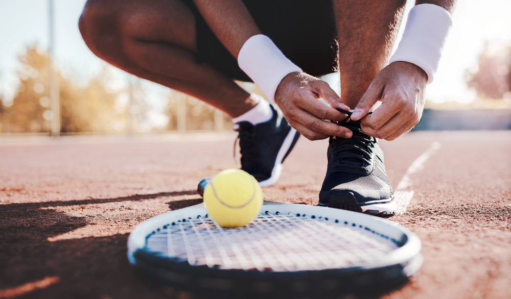 Tennis player tying sport shoes